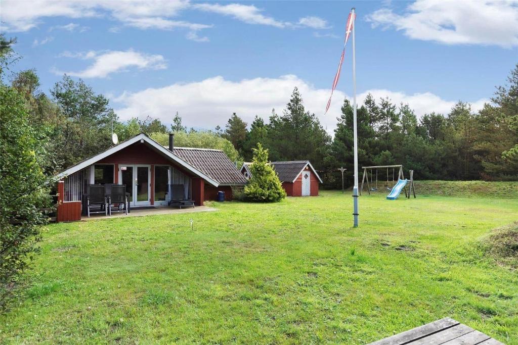 a small house with a flag in a yard at 0146-Romo-Ejnar-Mikkelsensvej-16 in Høm