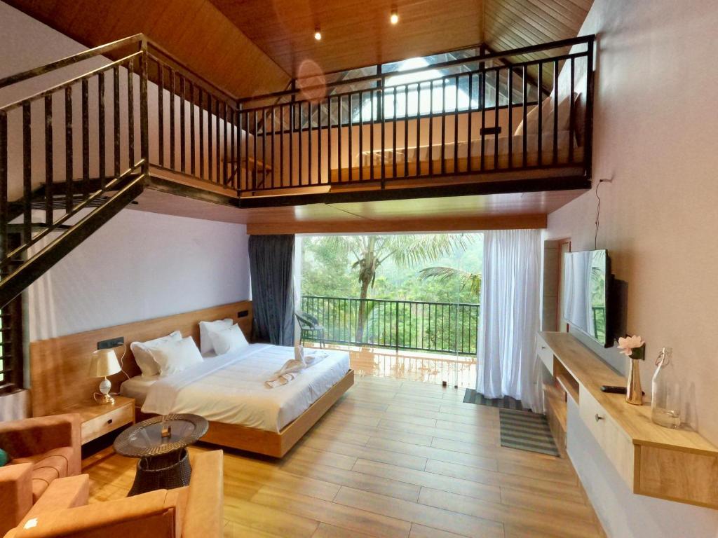 a bedroom with a large bed and a balcony at Mercure Resort Wayanad in Mananthavady