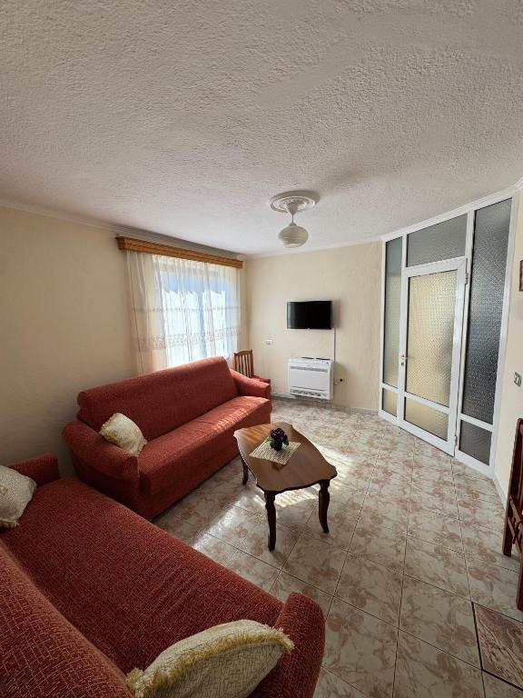 a living room with a red couch and a table at Central Stay Pogradec in Pogradec