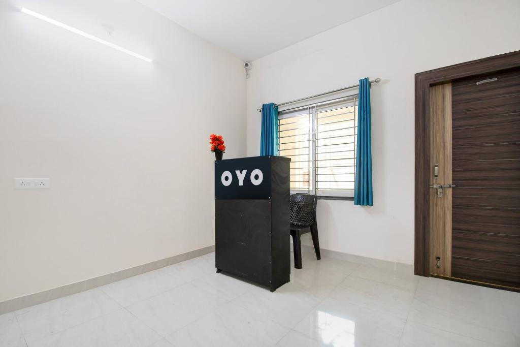 a room with a tv and a wooden door at Hotel O AMRITA PREMIUM in Bhubaneshwar