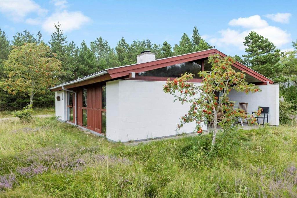 una piccola casa con un garage rosso e bianco di 0418-Romo-Sonderstrandvej-19 a Mølby