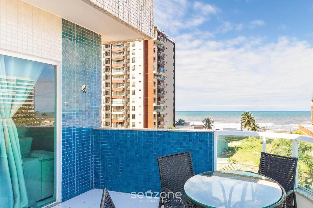a balcony with a glass table and chairs and the ocean at Apto c/ Vista Mar a 200m da Praia TSR0501 in Cururupe