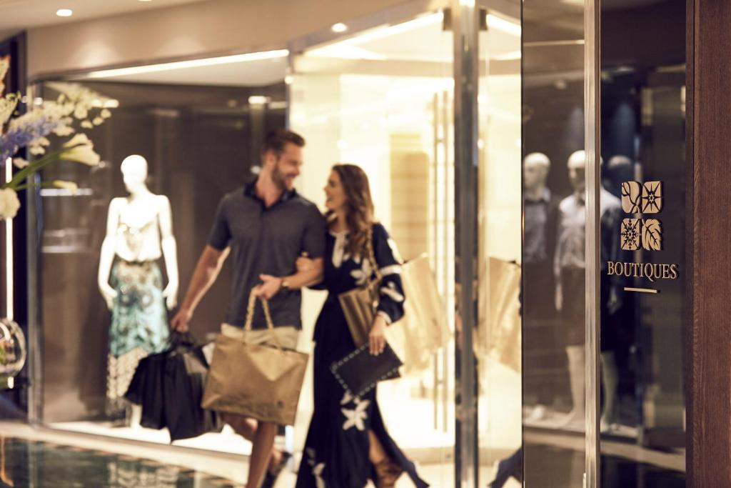 a man and a woman walking in front of a store window at Four Seasons Hotel in Limassol