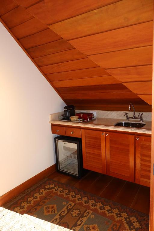 a kitchen with a sink and a stove at Hortênsia Boutique - Suites Privativas em Chalés de Luxo in Campos do Jordão