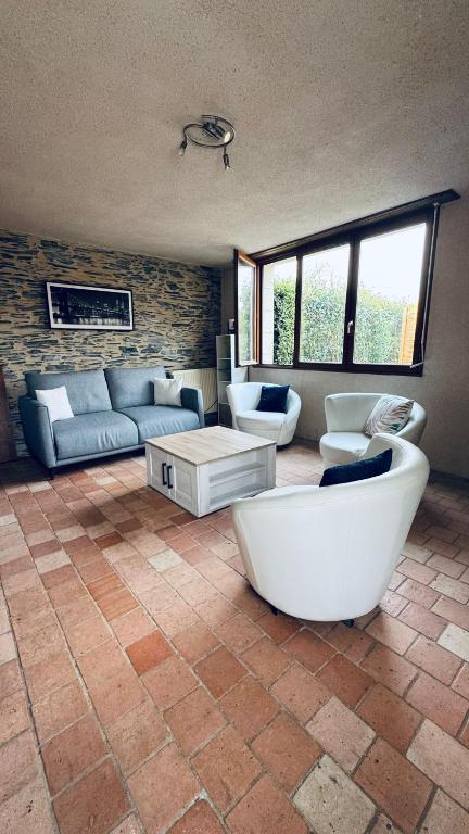 a large living room with a couch and a tub at Gîte La Loge in Corné