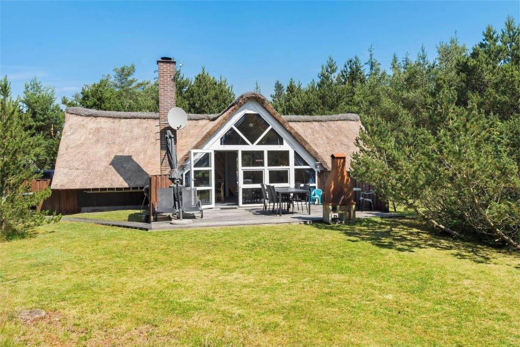 un cottage avec un toit de chaume sur un champ dans l'établissement 0142-Romo-Ivigtut-1, à Kongsmark