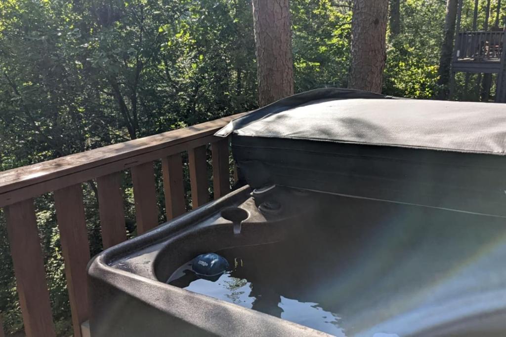 a bath tub sitting on top of a wooden deck at Authentic Log Cabin with Full Kitchen, Fireplace a in Eureka Springs