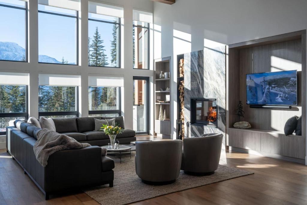 a living room with a couch and chairs and a tv at Sitka Spruce Mountain Chalet in Revelstoke