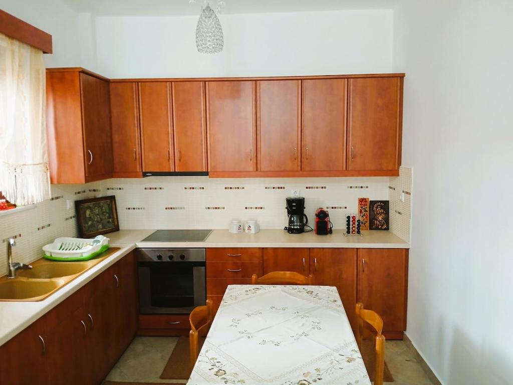 a kitchen with wooden cabinets and a table in it at Sogno Sulla Montagna in Lagadia