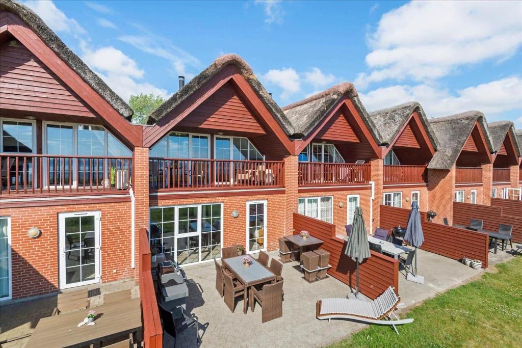 a large brick building with a patio with tables and umbrellas at 0236-Romo-Havnebyvej-61-G in Kongsmark