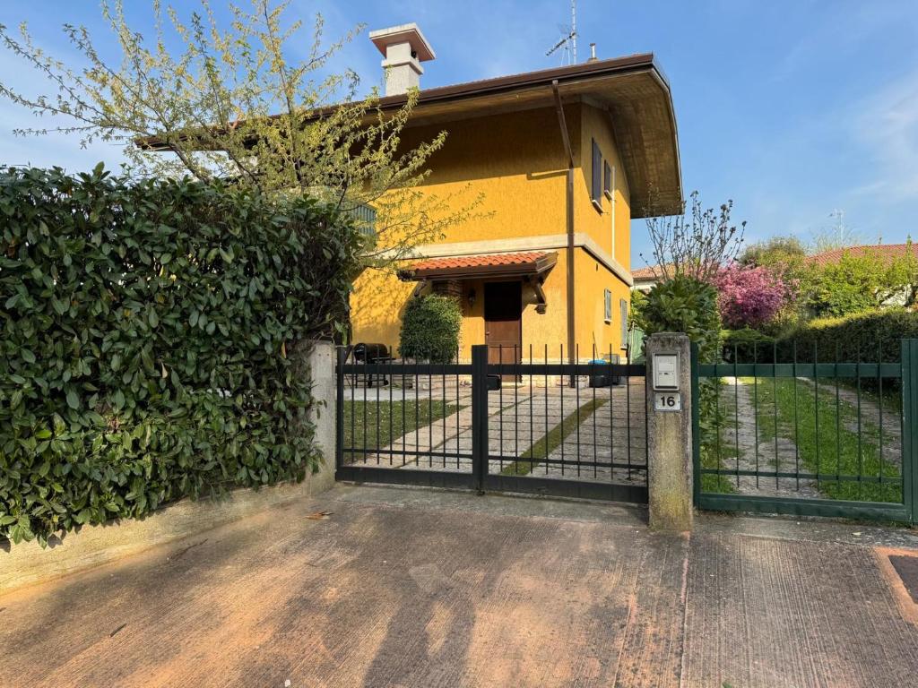 a yellow house with a gate in front of it at Mia's House on Lake Garda in Sirmione