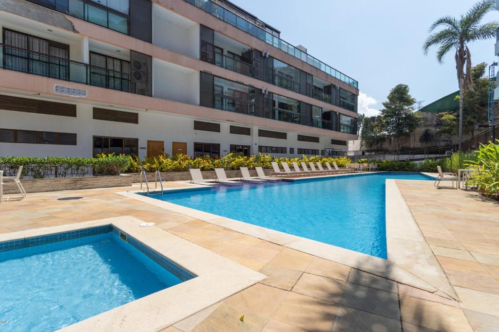 una piscina frente a un edificio en Apartamento em Itaipava com Piscina e Academia, en Itaipava