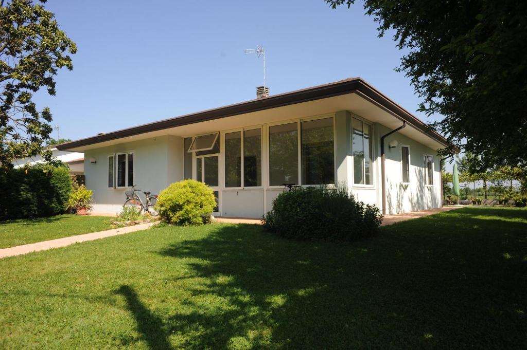 多洛的住宿－Casa Vacanze Riviera del Brenta，一间白色的小房子,设有大窗户和庭院