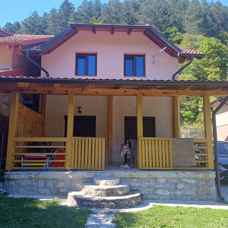 a house with a porch and stairs in front at Holiday House Ostrozac na Uni in Ostrožac