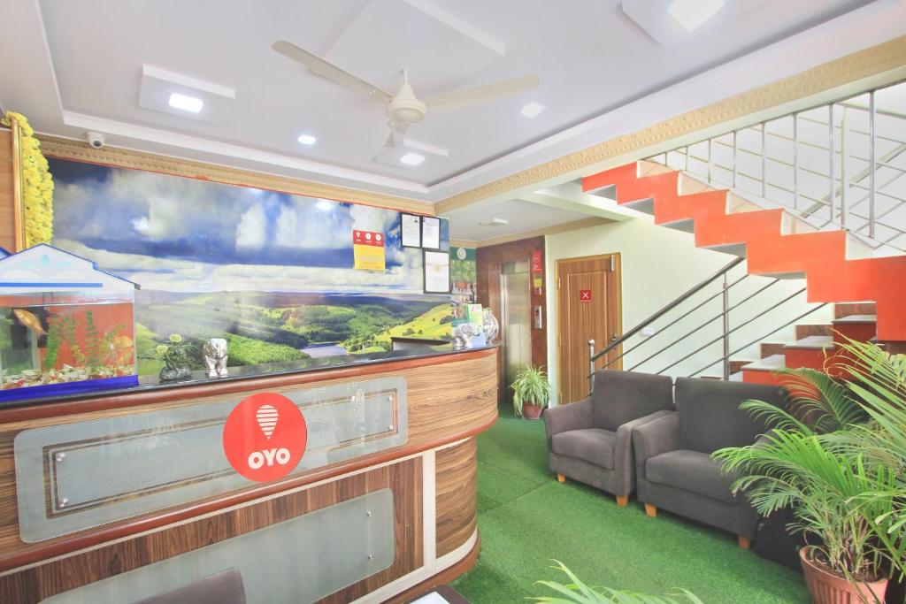 a lobby with a fish tank on the wall at Hotel O Garden Green in Bengaluru