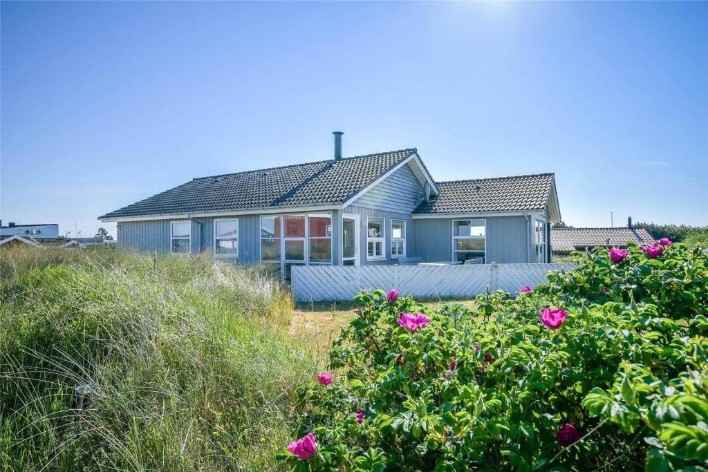 a blue house on the beach with pink flowers at 0073-Romo-Lakolk-172 in Lakolk