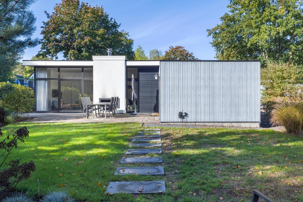a house with a white facade and a lawn at Holiday Home Maridu Family L-Cube in Arnhem