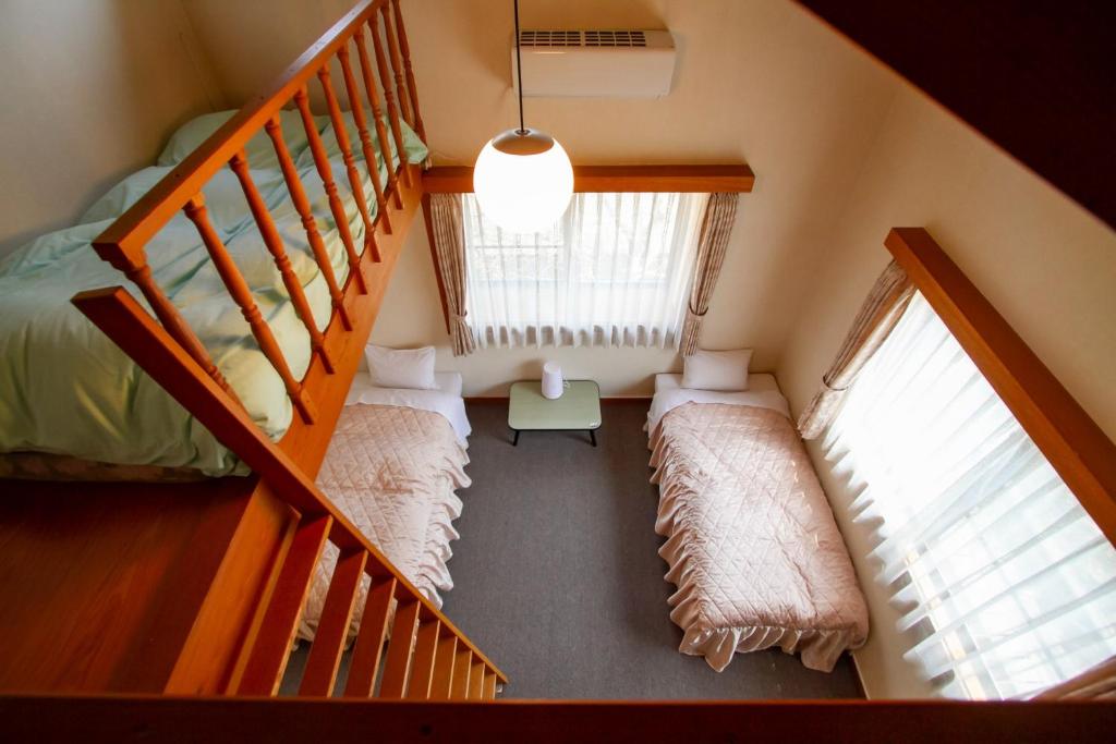 a attic room with two beds and a staircase at Kanon suisha - Vacation STAY 26662v in Kawaba