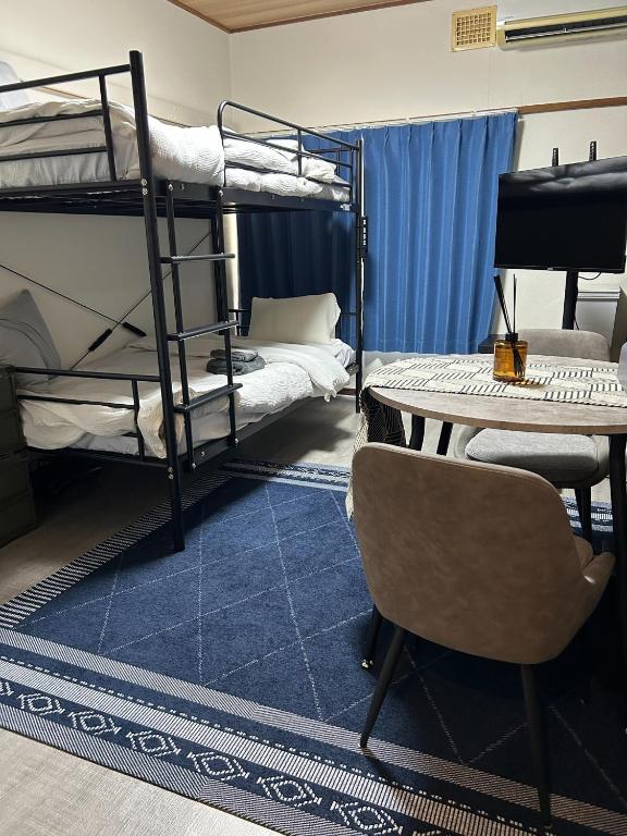 a room with bunk beds and a desk and a table at Sirius AMA - Vacation STAY 20068 in Tsukuba