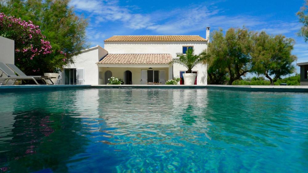 a swimming pool in front of a house at Mas des Cabidoules in Saintes-Maries-de-la-Mer