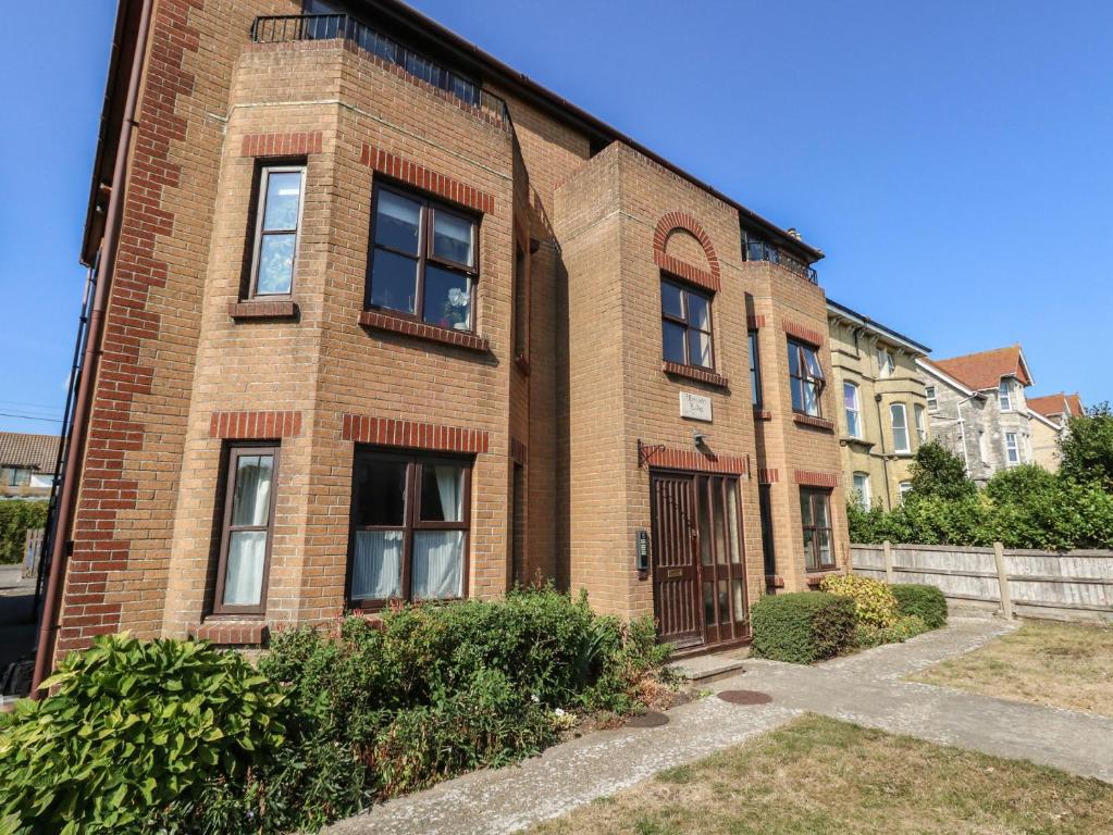 a brick building with windows and a fence at Flat 9 in Swanage