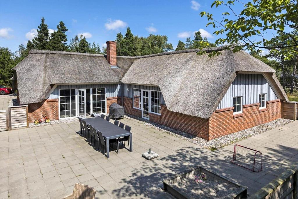 a house with a thatched roof and a patio at 0119-Romo-Smafolksvej-43 in Høm