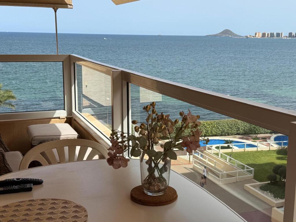 un vaso di fiori su un balcone con vista sull'oceano di La Manga Punta Cormoran Apartment a La Manga del Mar Menor