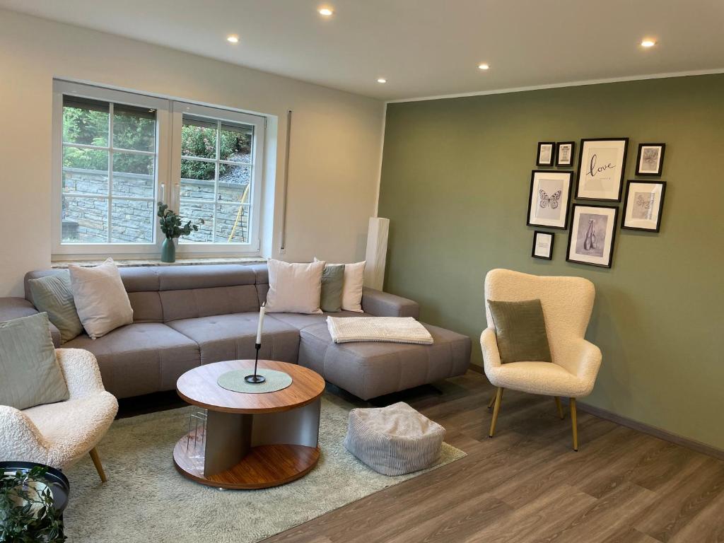 a living room with a couch and a table and chairs at Moderne Ferienwohnung ab März 2026 mit Saunabereich in Buchet