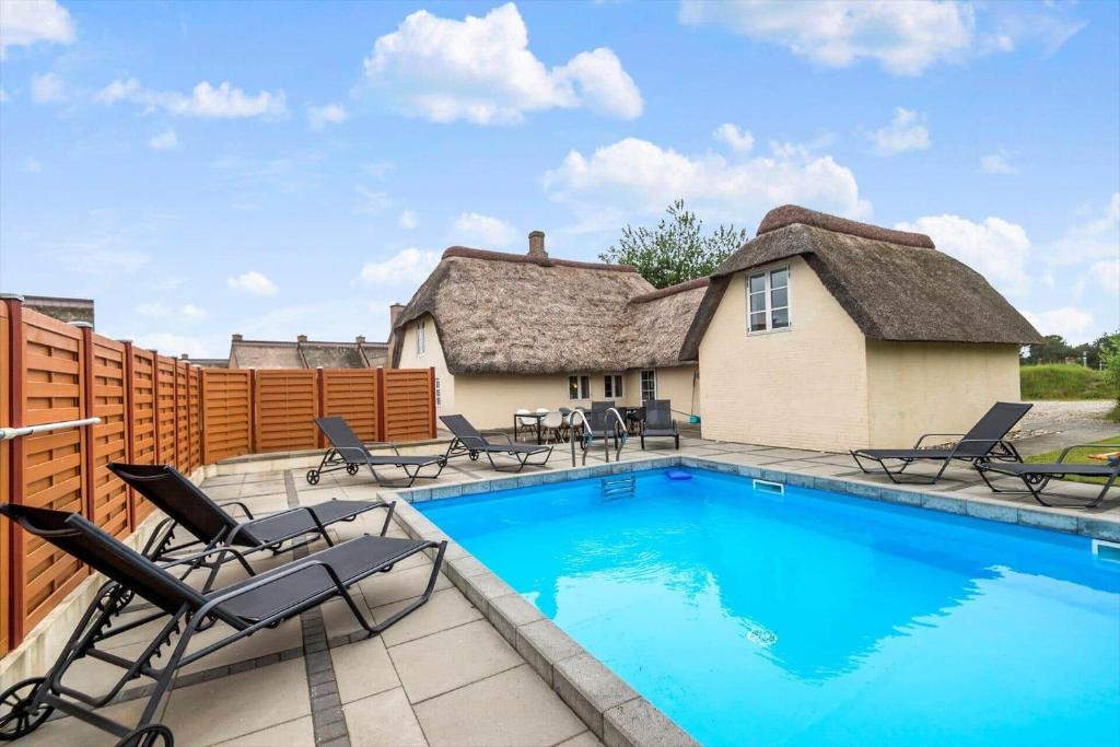 une piscine avec des chaises et une maison dans l'établissement 0499-Romo-Vestergade-29, à Sønderby