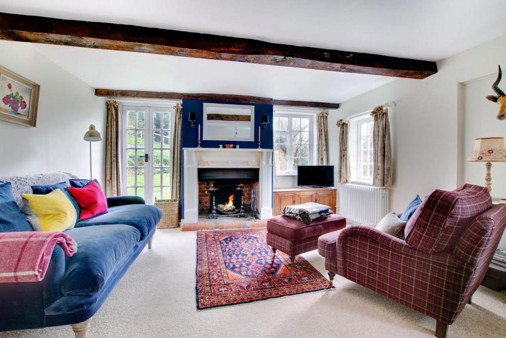 a living room with a couch and a fireplace at Mill Cottage in Ufford