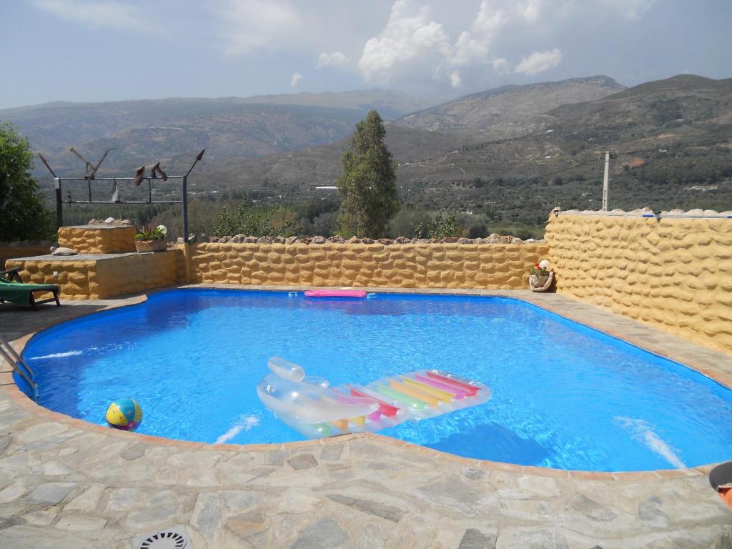 a swimming pool with a inflatable shark in the middle at Casas Amaro in Órgiva