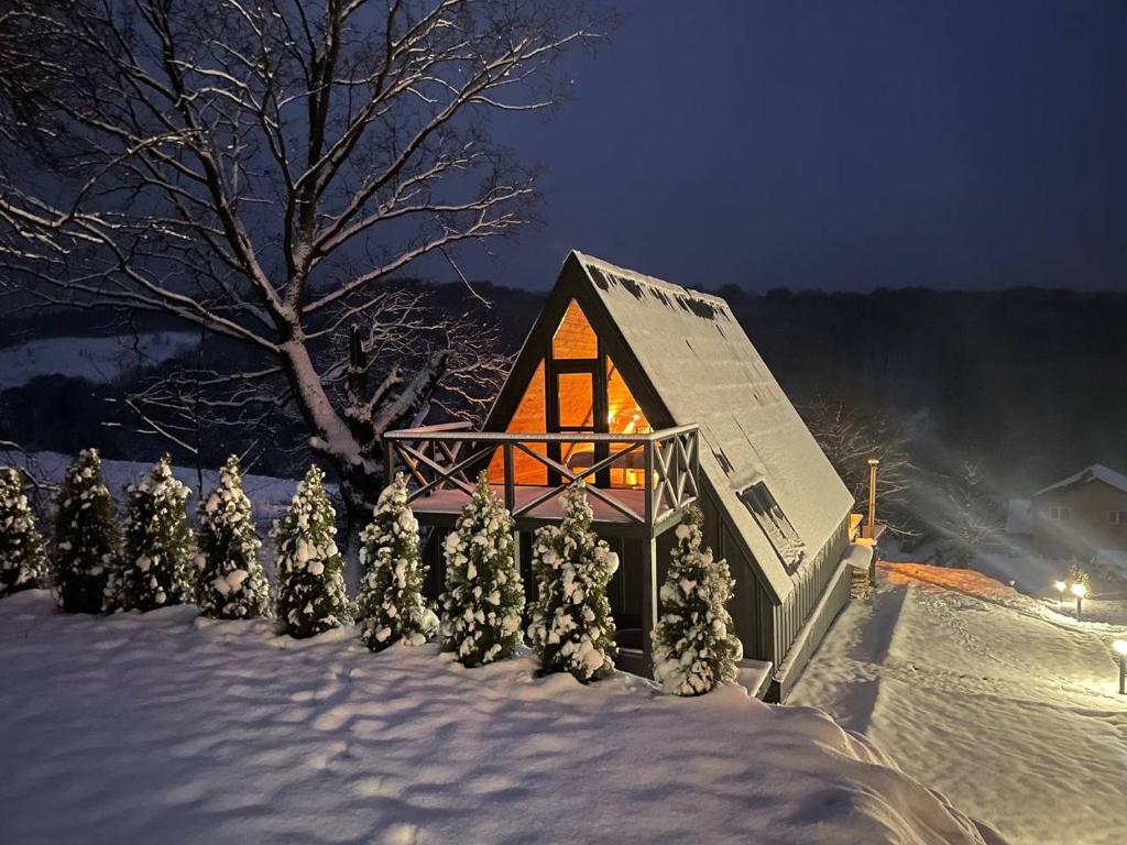 a small house in the snow at night at Lav inn Polyana Затишок in Polyana