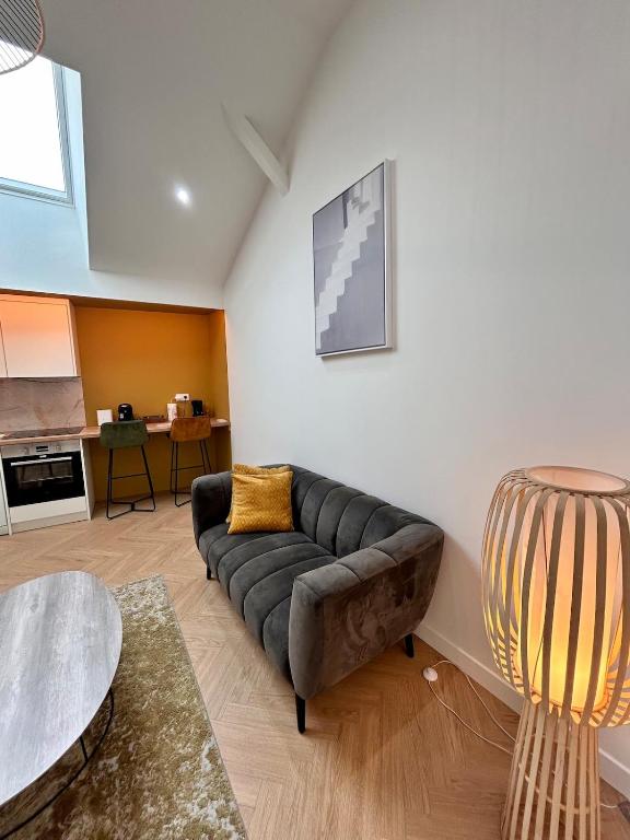 a living room with a couch and a table at Le Loft in Pont-de-Veyle