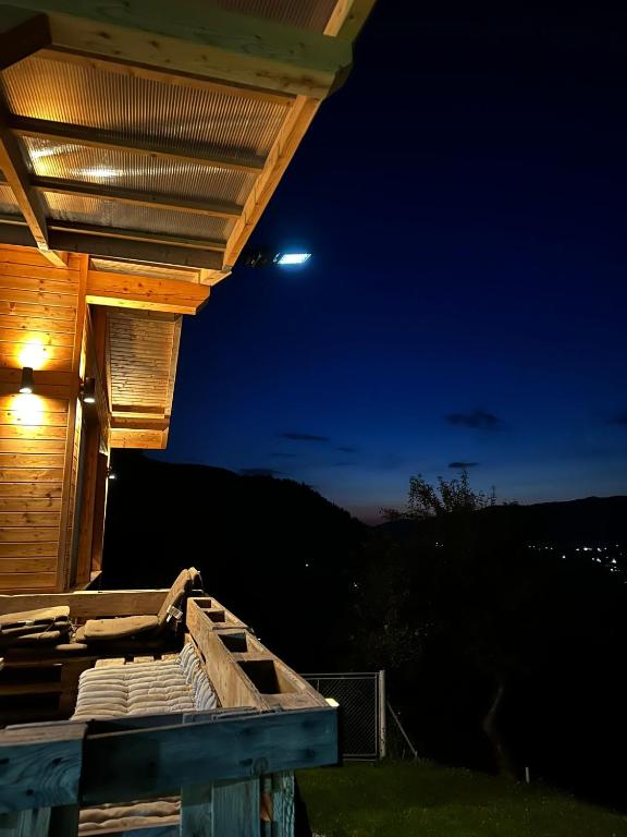 a night view of a wooden house with a moon at Montis House in Vişeu de Mijloc