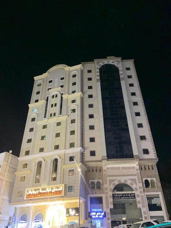 a tall white building with a sign on it at Ghazala Beautiful Hotel shuttle service to the Haram in Mecca