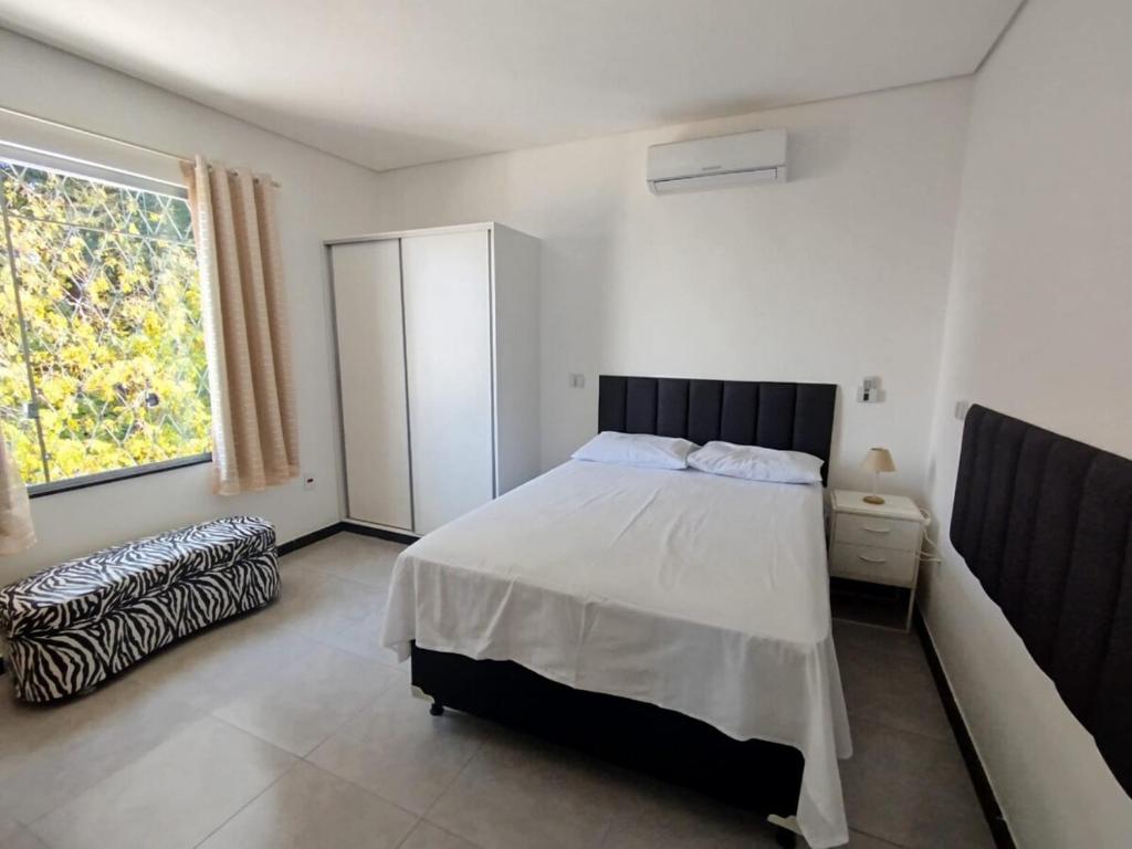 um quarto com uma cama grande e uma janela em casa Moderna com Ar do Campo em Contagem