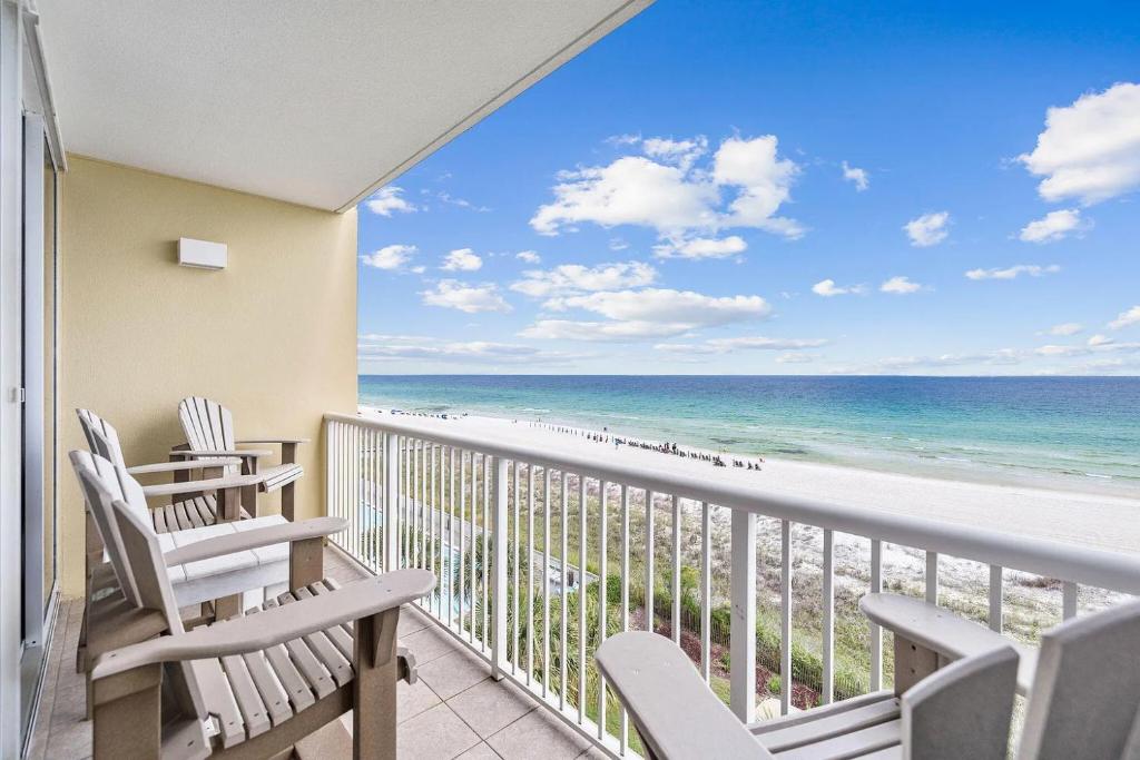 a balcony with chairs and a view of the beach at Waters Edge 504 - Direct Ocean Views - Free Beach Service in Fort Walton Beach