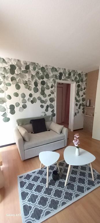 a living room with a couch and two tables at Appartement de 46M2 in Chasseneuil-du-Poitou