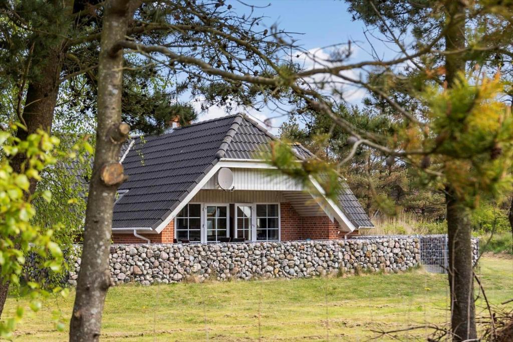 a small house with a stone wall in front of it at 2008-Romo-Froidal-10 in Toftum