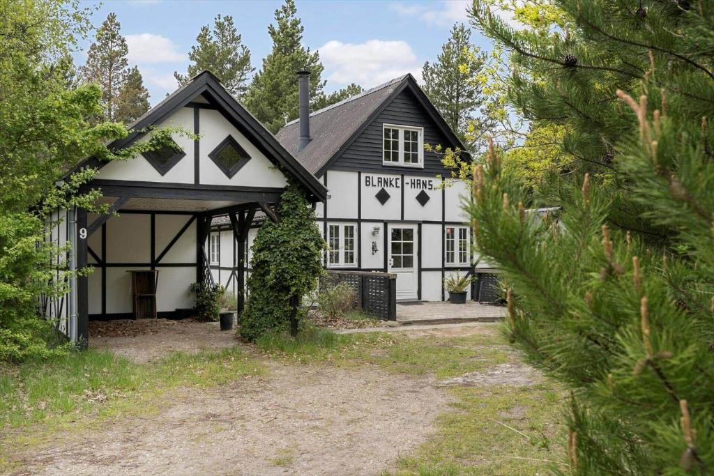 a white house with a black roof at 0496-Romo-Norre-Frankel-9 in Havneby