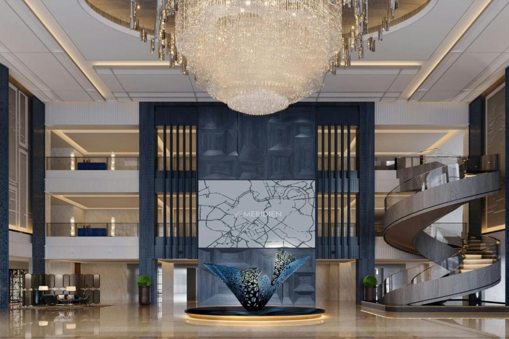 紹興市にあるLe Meridien Shaoxing Yuechengのシャンデリアと彫刻が中央に飾られたロビー