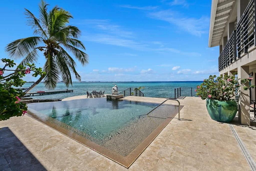 a swimming pool with the ocean in the background at Seven Mile View Condo #4 in West Bay