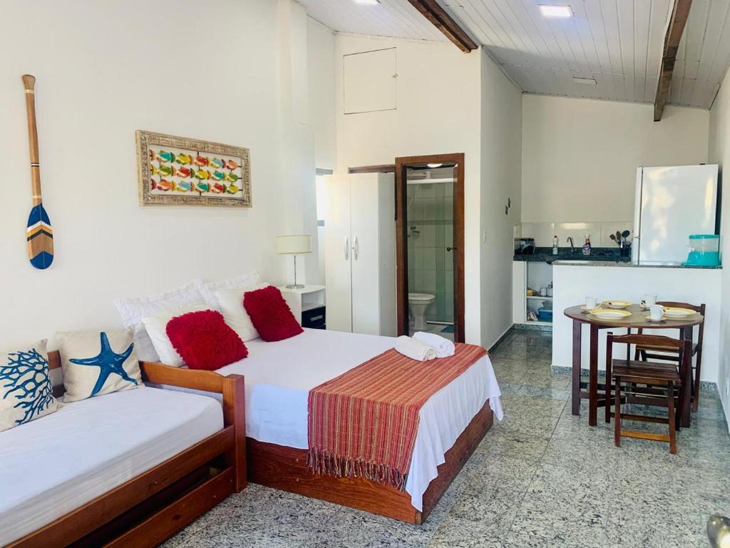 a bedroom with two beds and a table in it at pe na areia in Arraial do Cabo