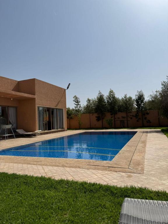 a swimming pool in front of a house at Atlas Mountain View Villa Marrakech in Marrakesh