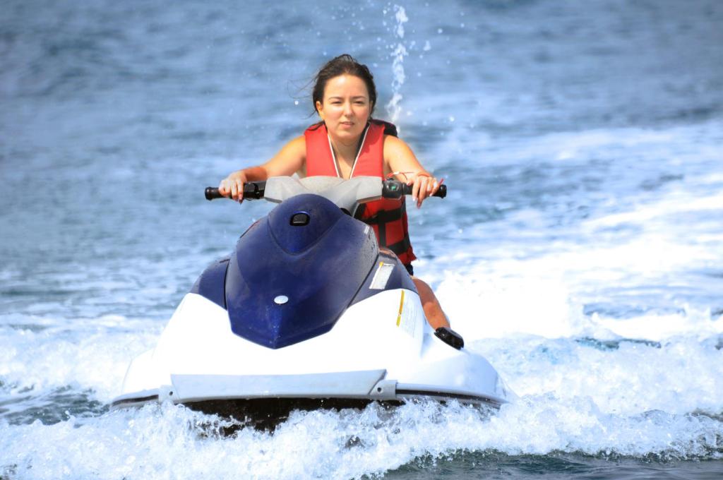 a woman riding on a jet ski in the water at Golden Lotus Hotel in Kemer