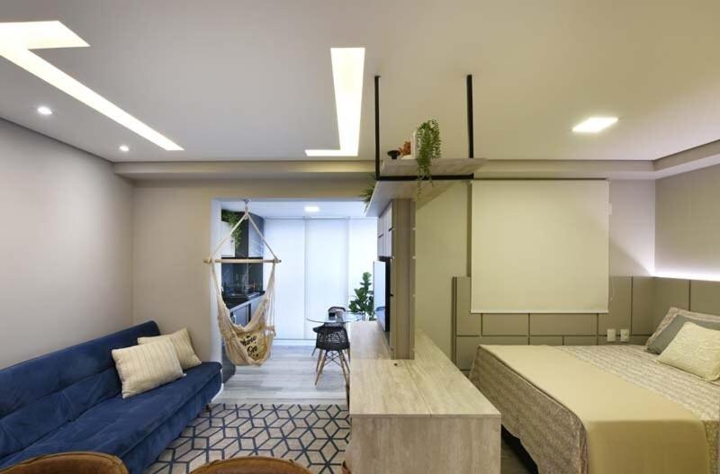 a bedroom with two beds and a blue couch at 1505 studio guarulhos in Guarulhos