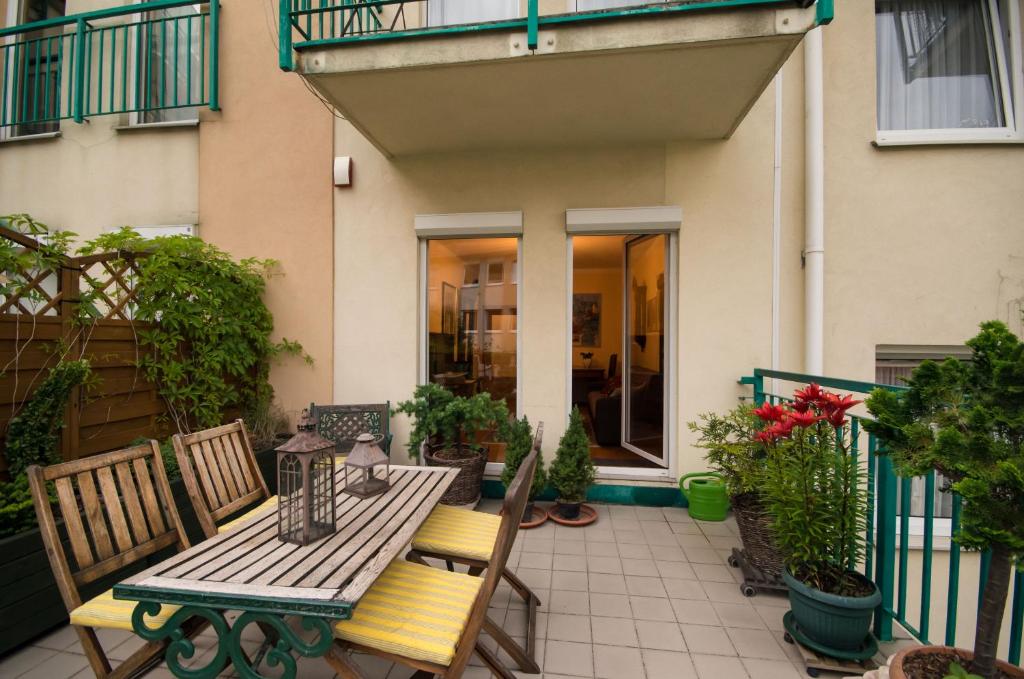 a patio with a table and chairs and a balcony at Apartament Mundus in Sopot