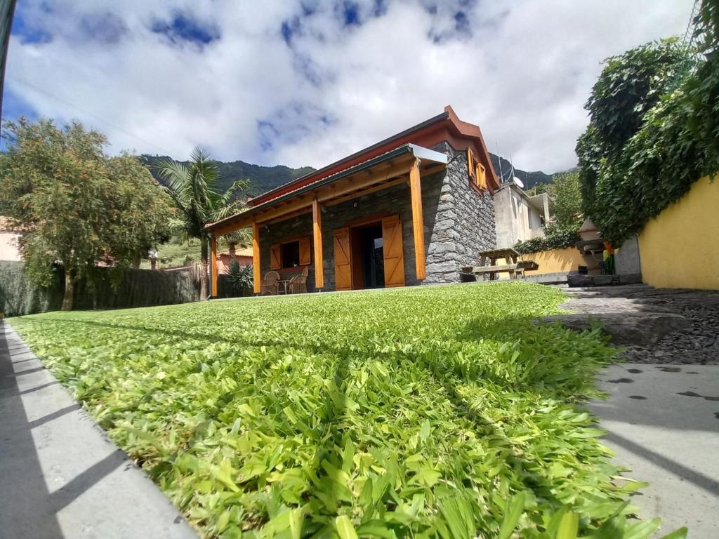 ein Haus mit einem grünen Rasen davor in der Unterkunft Refúgio do Limoeiro in São Vicente
