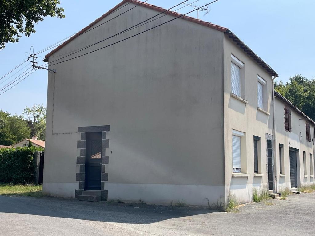 ein großes weißes Gebäude mit einer Seitentür in der Unterkunft Farmhouse in Montaigu-Vendée