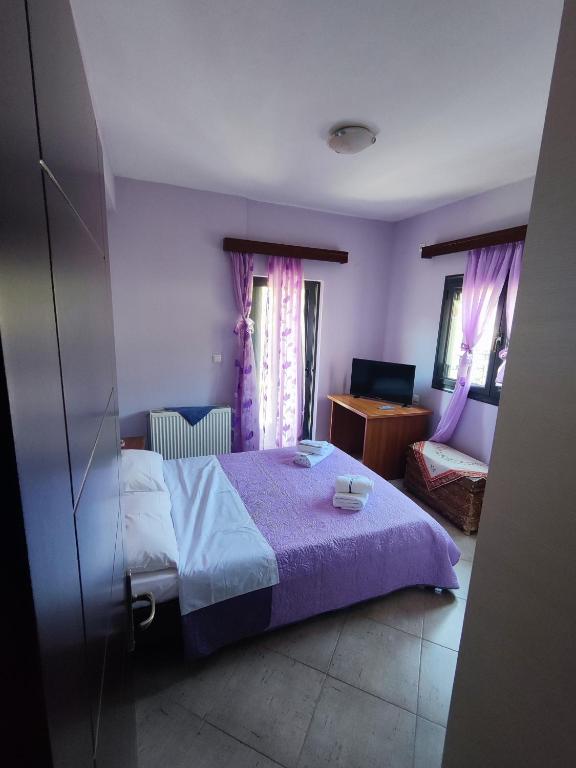 a bedroom with a bed with a purple bedspread at Villa Athamanio - Premium in Athamanio